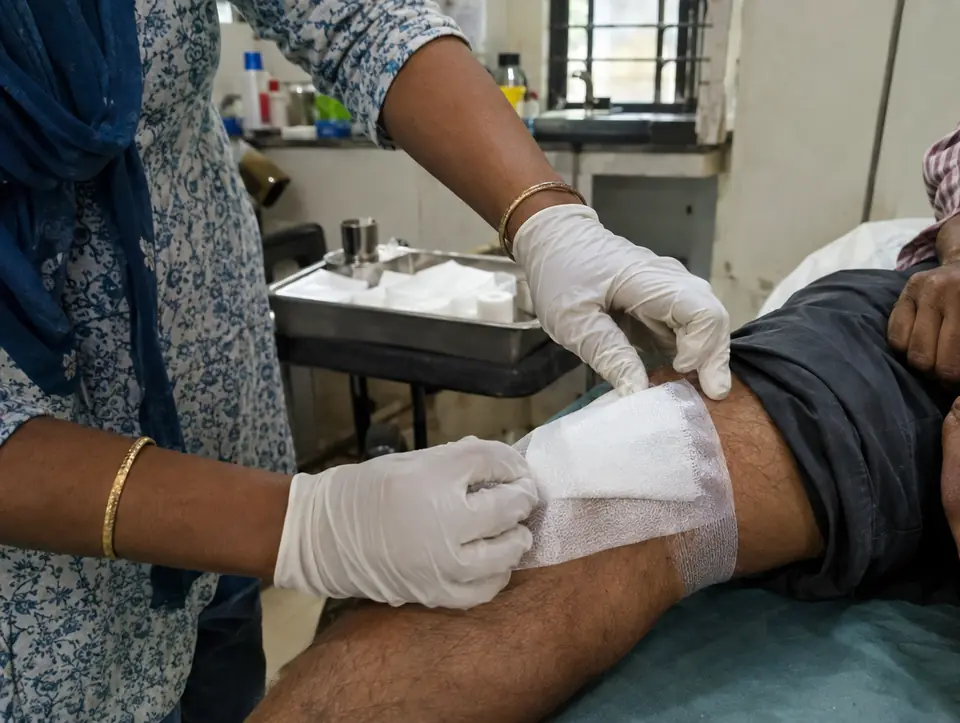 Gloved hands applying a fresh surgical dressing
