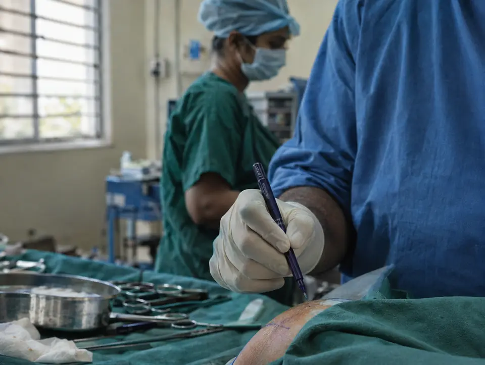 A surgeon's gloved hand holding a surgical marking pen